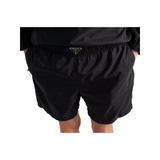 PRADA RE-NYLON LOGO BADGE SWIM SHORTS IN BLACK